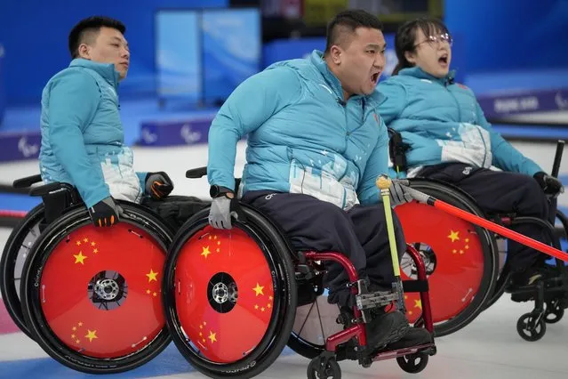 China's Wang Haitao, center, Yan Zhuo, right, and Zhang Mingliang react during their wheelchair curling match against Switzerland at the 2022 Winter Paralympics, Monday, March 7, 2022, in Beijing. (Photo by Dita Alangkara/AP Photo)