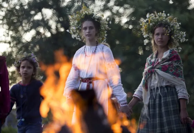 Belarussian girls walk around camp fire as they take part in the festival of national traditions “Piatrovski” in the village of Shipilovichi, south of Minsk, July 12, 2015. (Photo by Vasily Fedosenko/Reuters)