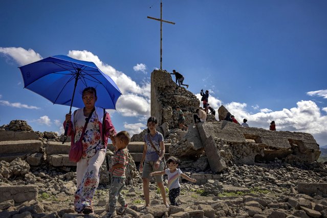 People visit the remnants of the old sunken town of Pantabangan on April 28, 2024 in Nueva Ecija province, Philippines. Due to a severe drought in the Philippines, a centuries-old settlement submerged since the 1970s has reemerged, attracting tourists despite the extreme heat. This event marks the sixth appearance of the nearly 300-year-old ruins of old Pantabangan town, including parts of a church and tombstones, since the construction of a dam for irrigation and hydro-power. The reservoir's water level has dropped nearly 50 meters below normal as the country faces extreme heat exacerbated by El Niño conditions, leading to official drought declarations in about half of the country's provinces. (Photo by Ezra Acayan/Getty Images)