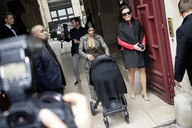 Kim Kardashian pushes a stroller next to Kanye West and her mother, Kris Jenner, right, as they leave their hotel in Paris, on May 23, 2014. (Photo by Kenzo Tribouillard/AFP Photo)