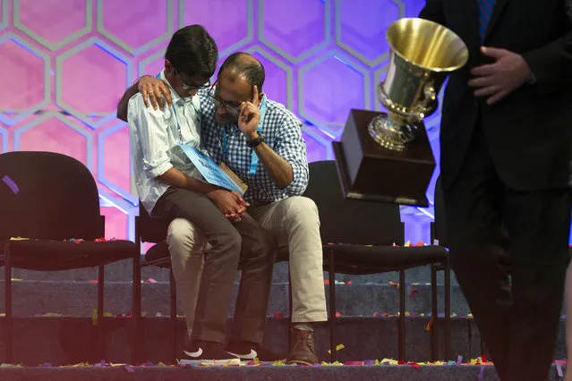 With the winners trophy passing by, Rohan Rajeev, 14, from Edmond, Okla., talks with his father Rajeev Muralidharan, moments after losing in the finals of the 90th Scripps National Spelling Bee in Oxon Hill, Md., Thursday, June 1, 2017.  (Photo by Cliff Owen/AP Photo)