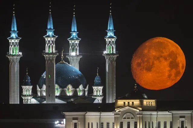 The full moon rises over the illuminated Kazan Kremlin with the Qol Sharif mosque illuminated in Kazan, the capital of Tatarstan, located in Russia's Volga River area about 700 km (450 miles) east of Moscow, early Wednesday, July, 29, 2015. (Photo by Denis Tyrin/AP Photo)