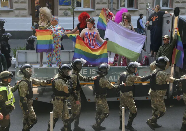 Ukrainian police guard the participants of the annual Gay Pride parade in Ukraine's capital Kiev, Ukraine, Sunday, June 18, 2017. Around five thousand gays and lesbians activists and associations paraded in the center of Kiev. (Photo by Efrem Lukatsky/AP Photo)