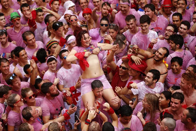Revelers celebrate during the launch of the “Chupinazo” rocket, to celebrate the official opening of the 2014 San Fermin fiestas, in Pamplona, Spain, Sunday, July 6, 2014. (Photo by Daniel Ochoa de Olza/AP Photo)