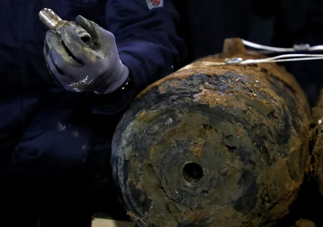 An explosive ordnance disposal service employee holds one of the detonators in his hand after the defusing of four unexploded bombs from the Second World War in Dortmund, Germany, 12 January 2020. 14,000 residents had to leave their homes and two hospitals had to be evacuated for the bomb defusing. (Photo by Friedemann Vogel/EPA/EFE)