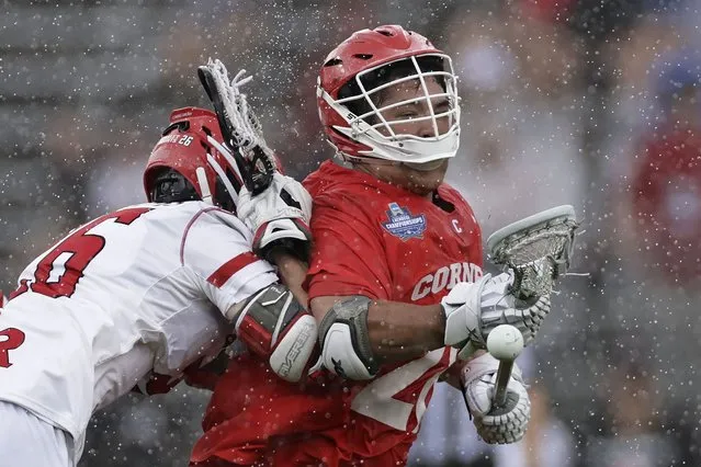 Cornell forward Angelo Petrakis (28) looses the ball after being hit by Rutgers midfielder Zackary Franckowiak during an NCAA lacrosse semi-finals game, Saturday, May 28, 2022, in East Hartford, Conn. (Photo by Adam Hunger/AP Photo)
