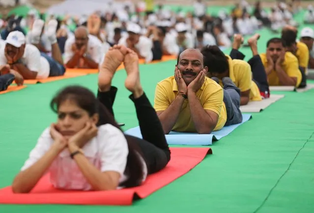 People perform yoga on the banks of the river Yamuna, during International Yoga Day in New Delhi, India, June 21, 2022. (Photo by Anushree Fadnavis/Reuters)