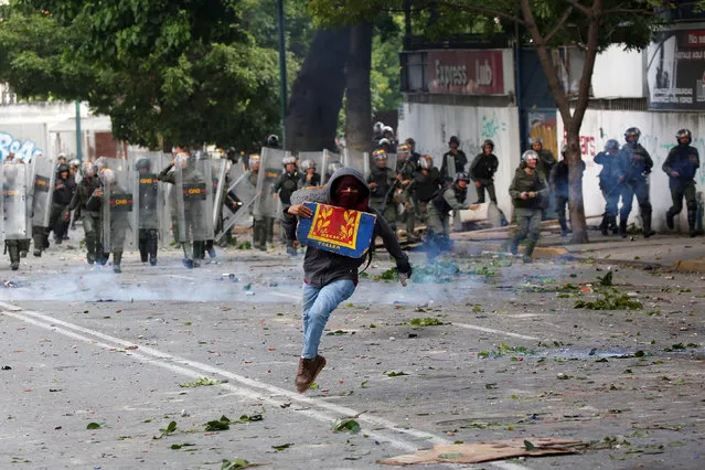 A demonstrator runs away from riot security force at a rally during a strike called to protest against Venezuelan President Nicolas Maduro's government in Caracas, Venezuela July 26, 2017. (Photo by Carlos Garcia Rawlins/Reuters)