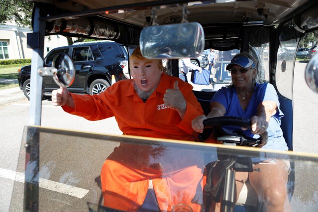 A supporter of Kamala Harris wears a jail costume with a Donald Trump mask while waiting to drop off their voting ballot at the Sumter County Supervisor of Elections Office during a golf cart rally in the retirement community of The Villages, Florida, on October, 14, 2024. (Photo by Octavio Jones/Reuters)