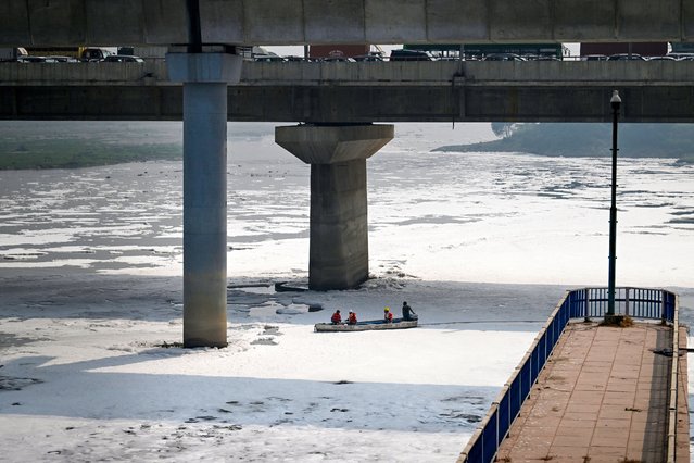 Civic workers spray defoamer on the polluted waters of river Yamuna laden with foam, in New Delhi on October 22, 2024. (Photo by Arun Sankar/AFP Photo)