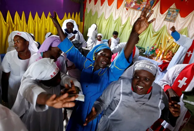 Faithful of the African Roho Musalaba Church sing hymns during a special service to pray for a peaceful presidential election in Kisumu Ndogo village in Kibera slums of Nairobi, Kenya, August 6, 2017. (Photo by Thomas Mukoya/Reuters)