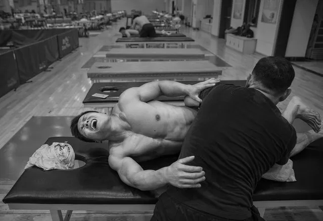 Chinese weightlifter Lu Xiaojun, who competes in the 77 kg weightclass, reacts as he is massaged after a training session in preparation for the Rio Olympics at the Training Center of General Administration of Sports in China on July 15, 2016 in Beijing, China. Xiaojun has won 5 World Championships, a gold medal at the 2012 Olympics and is a world record holder. (Photo by Kevin Frayer/Getty Images)