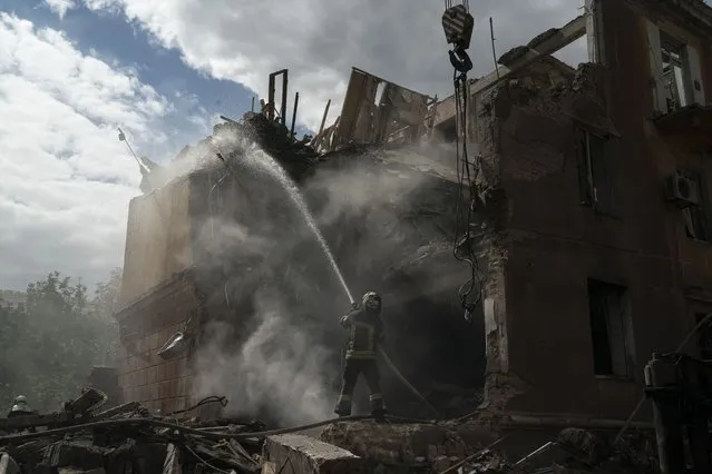 A firefighter works to extinguish a fire after a Russian attack that heavily damaged a residential building in Sloviansk, Ukraine, Wednesday, September 7, 2022. (Photo by Leo Correa/AP Photo)