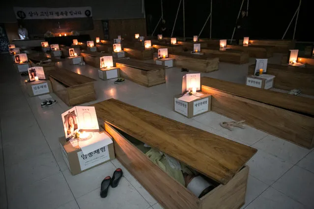 Participants reflect on their lives as they lie down inside coffins during a “Death Experience/Fake Funeral” session held by Happy Dying on August 1, 2016 in Andong, South Korea. Fifty adults who work at the Andong University in South Korea participated in the self-help seminar where participants reflect on their lives by experiencing the fake funeral of theirs. (Photo by Jean Chung/Getty Images)