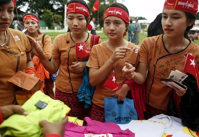 Ethnic Intha women buy shirts with National League for Democracy (NLD) party logo as they wait for the arrival of pro-democracy leader Aung San Suu Kyi at the Hopong township in Shan state, Myanmar September 6, 2015. (Photo by Soe Zeya Tun/Reuters)