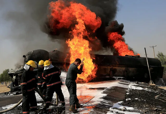 Afghan firefighters attempt to extinguish a burning fuel tanker which was hit by a magnetic bomb on the outskirts of Jalalabad, Afghanistan October 16, 2017. (Photo by Reuters/Parwiz)