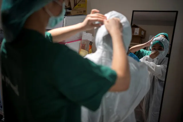 Nurse Tatsanee Onthong, 26, receives help from a colleague putting on her personal protective equipment (PPE) before attending to a COVID-19 patient in the Emerging Infectious Disease Clinic intensive care unit at King Chulalongkorn Memorial Hospital in Bangkok, Thailand, April 22, 2020. (Photo by Athit Perawongmetha/Reuters)