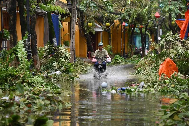 A man rides a motorbike in a flooded street following the passage of typhoon Noru in Hoi An city, Quang Nam province on September 28, 2022. (Photo by Nhac Nguyen/AFP Photo)