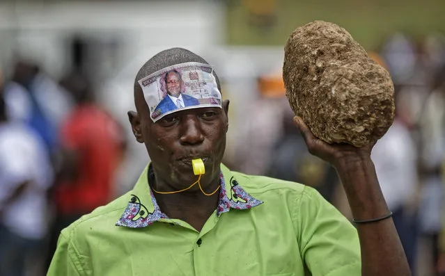 A supporter of opposition leader Raila Odinga wears a mock banknote with Odinga's face on his forehead at a rally in Uhuru Park in downtown Nairobi, Kenya Wednesday, October 25, 2017. Kenya's Supreme Court said Wednesday it could not hear a last-minute petition to postpone Thursday's presidential election because it didn't have a quorum of judges, while the shooting of one judge's driver hours before the hearing raised fears about intimidation. (Photo by Ben Curtis/AP Photo)