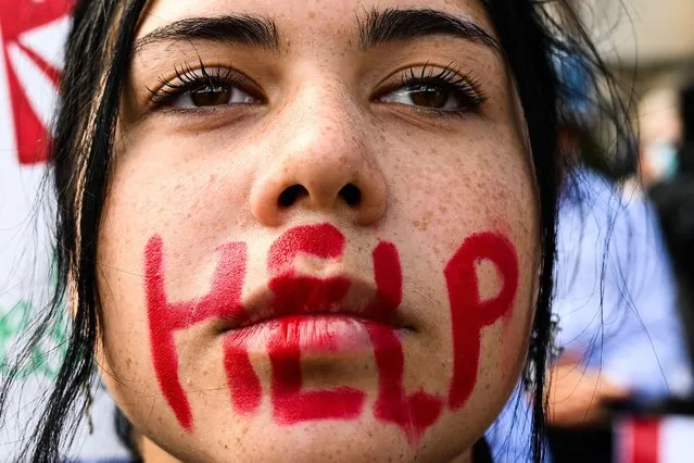 A young woman takes part in a protest on October 1, 2022 in Rome, following the death of Kurdish woman Mahsa Amini in Iran. Amini died in custody on September 16, 2022, three days after her arrest by the notorious morality police in Tehran for allegedly breaching the Islamic republic's strict dress code for women. (Photo by Vincenzo Pinto/AFP Photo)