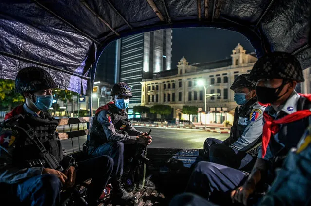 Police personnel sit on a vehicle as they patrol on a road amid concerns over the spread of the COVID-19 coronavirus, in Yangon on April 18, 2020. The Yangon government announced a 10pm to 4am curfew to begin on April 18 amid fears of the COVID-19 coronavirus pandemic. (Photo by Ye Aung Thu/AFP Photo)