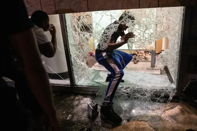 People climb into a damaged store during a protest against the death in Minneapolis police custody of George Floyd, in the Manhattan borough of New York City, U.S., June 1, 2020. (Photo by Jeenah Moon/Reuters)