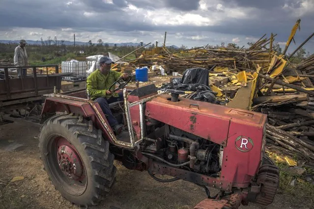 Tobacco farmer Hirochi Robaina drives his tractor past destroyed tobacco barns on his farm one week after Hurricane Ian in San Luis, in Pinar del Rio province, Cuba, Wednesday, October 5, 2022  (Photo by Ramon Espinosa/AP Photo)