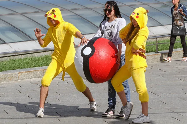Young people wearing Pokemon costumes hunt the passers-by exactly the way people hunt Pokemons playing the “Pokemon Go” game with their smartphones and tablets in Kiev, Ukraine on August 15, 2016. Launched at the beginning of July by the US company Niantic, the mobile phone game “Pokemon Go” has found a real success worldwide and already have generated more than 160 US million dollars. (Photo by Sergii Kharchenko/ZUMA Press/Splash News)