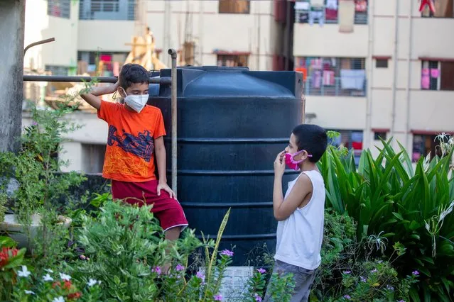 Bangladeshi child's wears a face mask as they talk to their rooftop at the residential area in Dhaka, Bangladesh 20 June 2020. Countries around the world are taking increased measures to stem the widespread of the SARS-CoV-2 coronavirus which causes the COVID-19 disease. (Photo by Monirul Alam/EPA/EFE/Rex Features/Shutterstock)