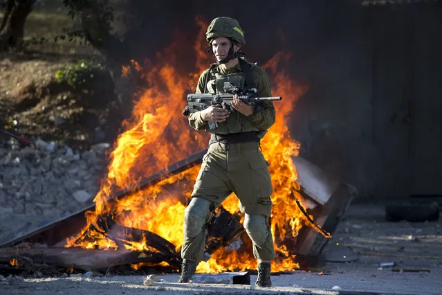 Israeli soldier stands during clashes with Palestinians following a protest against U.S. President Donald Trump's decision to recognize Jerusalem as the capital of Israel in the West Bank City of Nablus, Friday, December 8, 2017. (Photo by Majdi Mohammed/AP Photo)