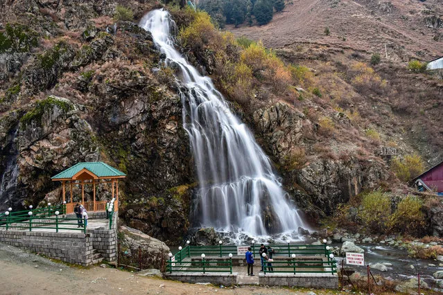 Visitors explore the waterfall during a cold autumn day in Drang about 40kms from Srinagar, the summer capital of Jammu and Kashmir on November 10, 2022. (Photo by Saqib Majeed/SOPA ImagesE/Rex Features/Shutterstock)