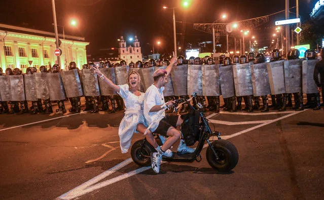 Protesters ride an electric bike in front of police during a protest after polling stations closed at the presidential elections in Minsk, Belarus, 09 August 2020. Five candidates are contesting for the presidential seat, including the incumbent president Lukashenko. (Photo by Tatyana Zenkovich/EPA/EFE)