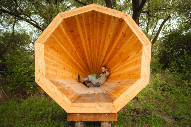 Matej Repel, director of Avescentrum Senne enjoys the sound of nearby birds as he sits inside a huge birdsong-amplifier that was recently installed for visitors, on April 24, 2025 near Michalovce, Slovakia. The 3 meter tall and 5 meter deep wooden amplifier is a unique installation in the country and was inspired by a similar amplifier based on a student's project in Estonia. (Photo by Robert Nemeti/Anadolu via Getty Images)