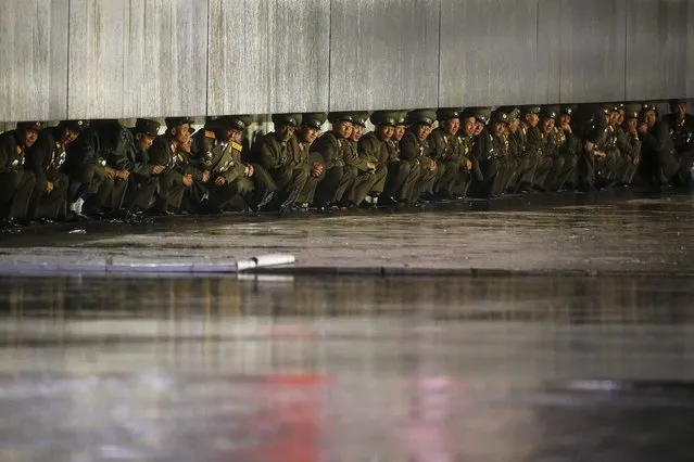 North Korean officers shield themselves from the rain after the parade celebrating the 70th anniversary of the founding of the ruling Workers' Party of Korea, in Pyongyang October 10, 2015. (Photo by Damir Sagolj/Reuters)