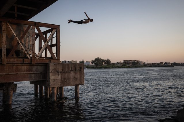 A boy dives into the water on the banks of the Euphrates River on June 3, 2025 in Raqqa, Syria. The land around Raqqa, which was a regular flashpoint in Syria's nearly 14-year civil war, is littered with landmines, cluster munitions, other unexploded bombs and improvised explosive devices. (Photo by Ed Ram/Getty Images)