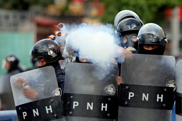 A police officer fires tear gas during clashes with demonstrators as Honduran President Juan Orlando Hernandez is sworn in for a new term in Tegucigalpa, Honduras on January 27, 2018. (Photo by Edgard Garrido/Reuters)