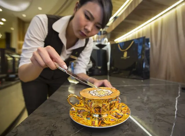 Assel Utelbayeva, a barista from the Ritz-Carlton hotel, places eatable gold flakes into a cup of cappuccino called "The Golden Horde" in Almaty, Kazakhstan, October 16, 2015. The Ritz-Carlton hotel offers cup of coffee worth 3000 Tenge (10.8 USD) marking the 550th anniversary of the Kazakh khanate. Three cups were sold since the launch of the promotion on October 15. (Photo by Shamil Zhumatov/Reuters)