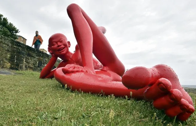 A visitor looks at a sculpture by a Chinese artist Chen Wenling at the "Sculpture by the Sea" exhibition which runs along the Bondi to Tamarama coastal walk in Sydney on October 22, 2015. The world's largest annual free-to-the-public outdoor sculpture exhibition runs from October 22 – November 8 this year and features over 107 sculptures by artists around the world. (Photo by Saeed Khan/AFP Photo)