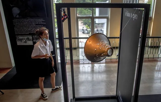A university student views a bullet-ridden megaphone as part of an exhibition from a student massacre over 40 years ago at the Thammasat University, in Bangkok, Thursday, October 1, 2020. (Photo by Gemunu Amarasinghe/AP Photo)