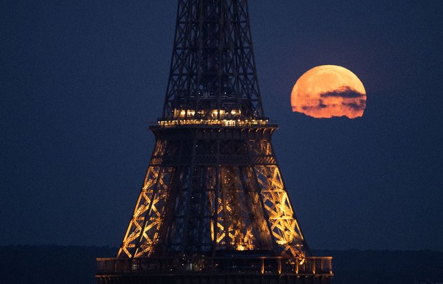 This photograph taken in Paris on April 23, 2024, shows the April's full moonset, also known as the Pink Moon, seen behind the Eiffel Tower. (Photo by Stefano Rellandini/AFP Photo)
