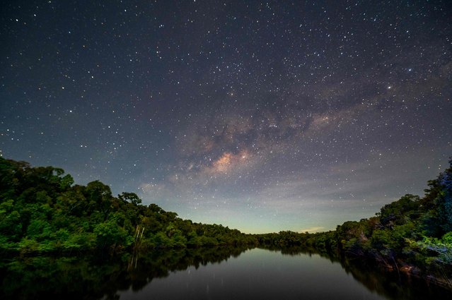 View of the night sky illuminating the Manicore river, located in the municipality of Manicore, Amazonas state, Brazil, in the Amazon rainforest, on June 07, 2022. (Photo by Mauro Pimentel/AFP Photo)