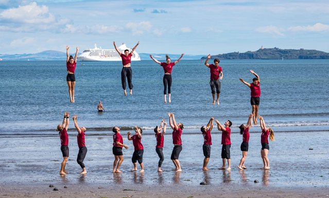Edinburgh Festival Fringe Genesis: The seventeen strong cast of Copenhagen Collective's premiere at fringe throwing tricks in the sea and on the pier at Wardie Bay in Edinburgh, Scotland on July 30, 2025. (Photo by Sally Anderson/Alamy Live News)