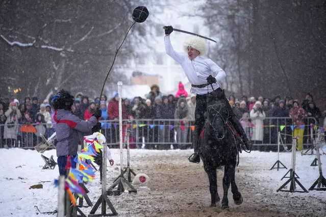 A rider shows off his skills during thr Maslenitsa (Shrovetide) holiday celebrations in St. Petersburg, Russia, Sunday, February 26, 2023. Maslenitsa is an Orthodox Christian holiday celebrated in the last week before the Orthodox Lent. The festivities feature baking traditional pancakes, sleigh rides, sparring between groups of men and, finally burning the effigy of Maslenitsa. (Photo by Dmitri Lovetsky/AP Photo)