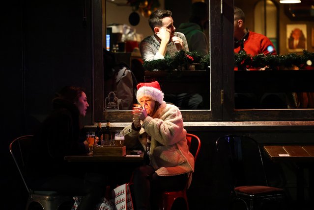 People sit outside a bar, as the spread of the coronavirus disease (COVID-19) continues, in London, Britain, December 15, 2020. (Photo by Henry Nicholls/Reuters)