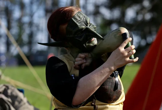 A woman dressed as a character from the computer game “World of Warcraft” prepares for a battle near the town of Kamyk nad Vltavou, Czech Republic, April 28, 2018. (Photo by David W. Cerny/Reuters)