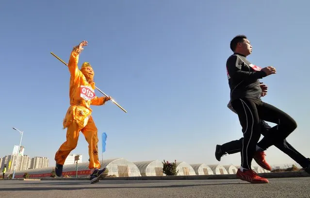 A runner (L) dressed in a traditional Chinese “monkey king” costume participates in a running competition to embrace the coming new year in Handan, in northern China's Hebei province on December 31, 2014. People from different part of China celebrate the coming 2015 in different ways according to their culture and traditions. (Photo by AFP Photo)