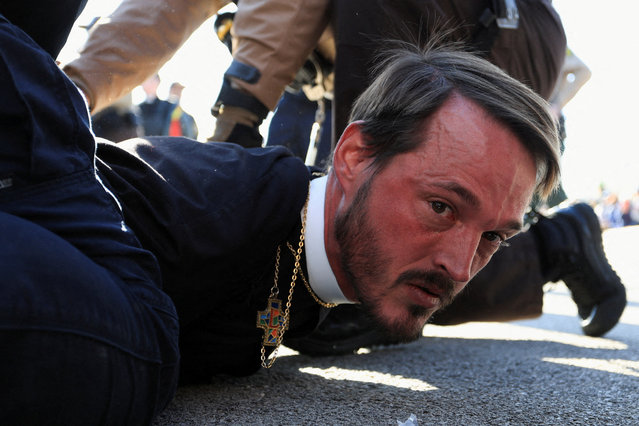 Faith leader, Michael Woolf, minister at Lake Street Church of Evanston, is detained by Illinois State Police during a protest against immigration actions, outside the Broadview ICE facility in Chicago, Illinois, on November 14, 2025. (Photo by Jim Vondruska/Reuters)