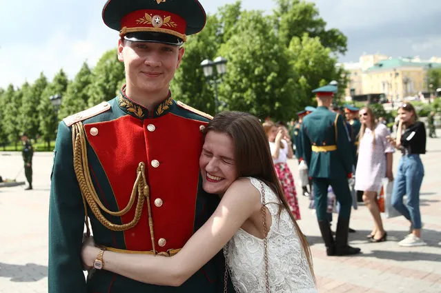 A serviceman of the 154 th Preobrazhensky Independent Commandant' s Regiment of Russia hugged by a girl after a retirement ceremony in Moscow' s Alexander Garden by the Kremlin Wall in Moscow, Russia on May 18, 2018. (Photo by Valery Sharifulin/TASS)