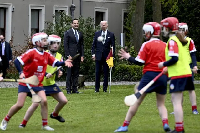 President Joe Biden and Taoiseach Leo Varadkar of Ireland watch as girls play hurling during a youth Gaelic sports demonstration at Farmleigh House in Dublin, April 13, 2023. (Photo by Kenny Holston/The New York Times)