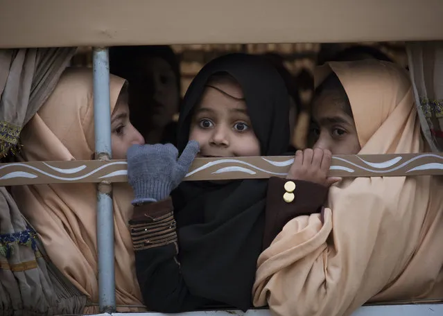 Pakistani students look out from a vehicle on their way to school near the Army Public School which was targeted by Taliban militants last year, in Peshawar, Pakistan, Monday, January 12, 2015. (Photo by B.K. Bangash/AP Photo)